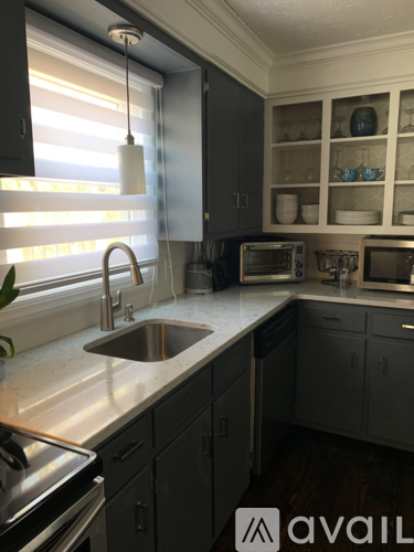 A kitchen with a sink and a window with blinds.