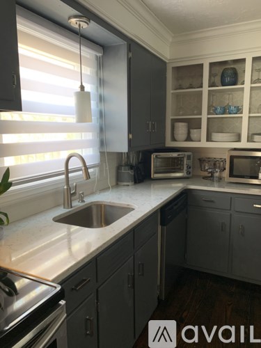 A kitchen with a sink and a window with blinds.