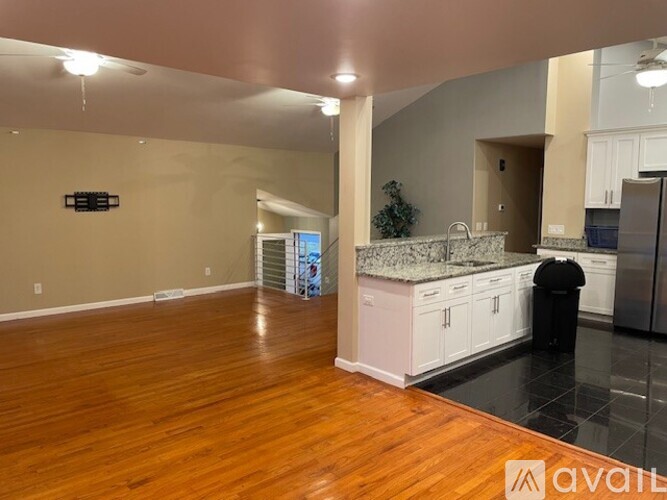A kitchen with white cabinets and a granite countertop is available.