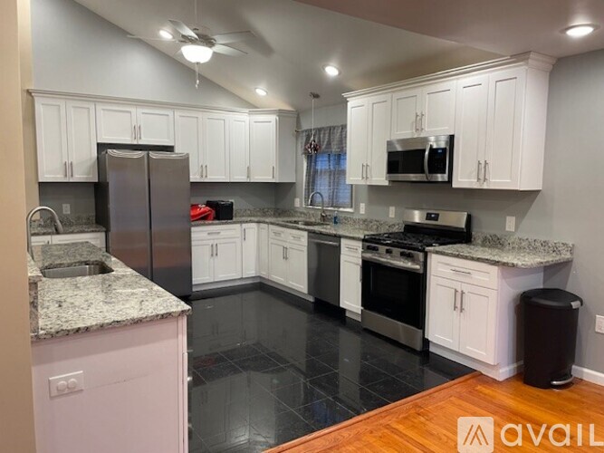 A kitchen with white cabinets and a marble countertop.