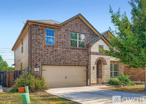A house with a garage and a driveway in front of it.