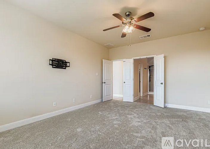 A spacious room with a ceiling fan and a carpeted floor.