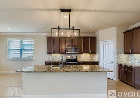 A kitchen with brown cabinets and a granite countertop.