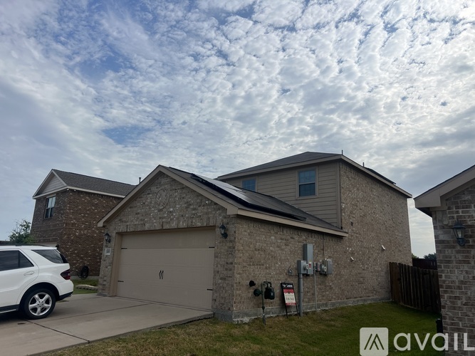A house with a garage and a car parked in front.