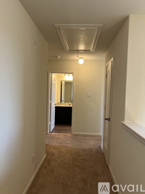 A hallway with a carpeted floor and a light on.