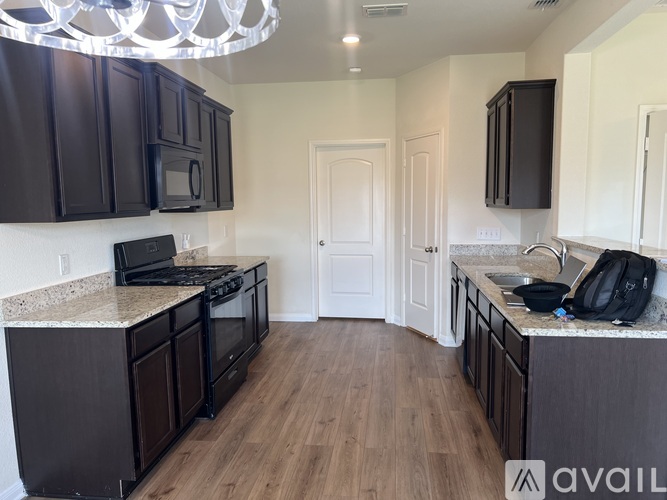 A kitchen with dark brown cabinets and a white countertop.