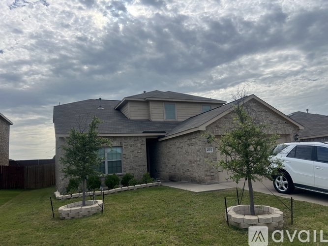 A house with a stone exterior and a white car parked in the driveway.