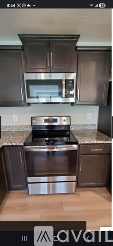 A kitchen with dark brown cabinets and stainless steel appliances.