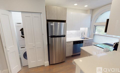 A kitchen with a refrigerator, washing machine, and a dishwasher.
