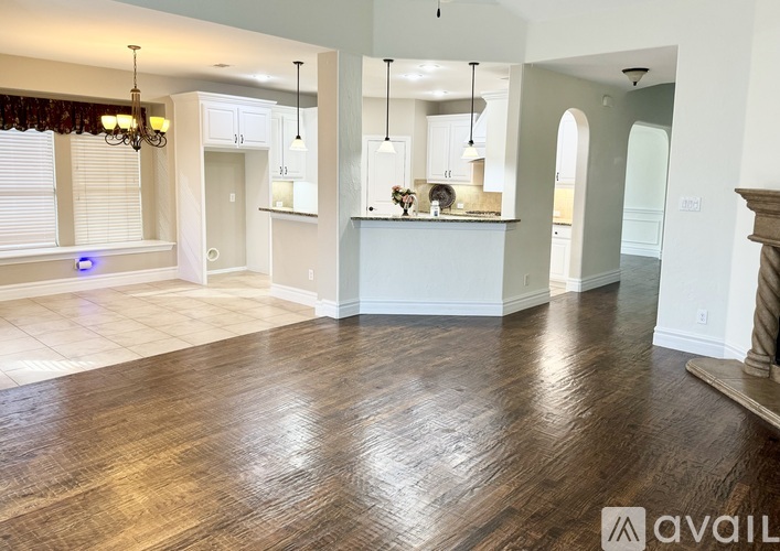A spacious living room with hardwood floors and a central island.