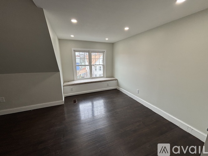 A room with a window and wooden flooring.