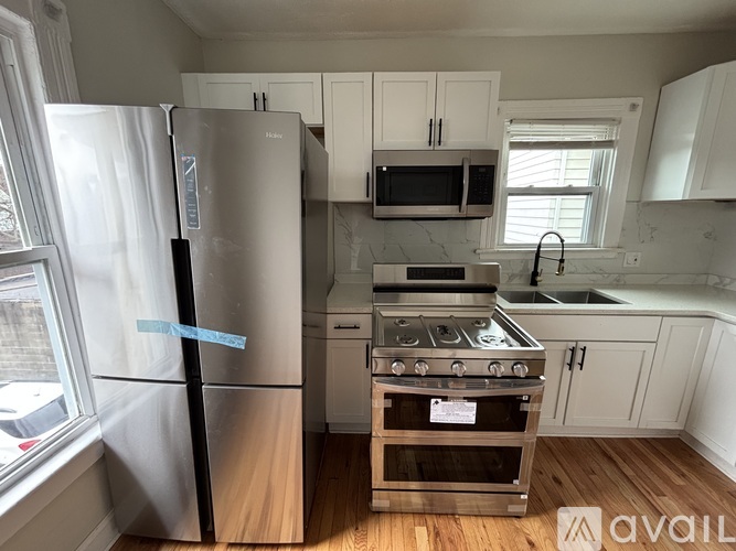 A kitchen with a refrigerator, oven, and microwave.