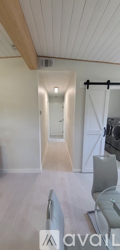 A spacious room with a white ceiling and a long hallway.