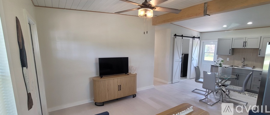 A living room with a television and a dining area.
