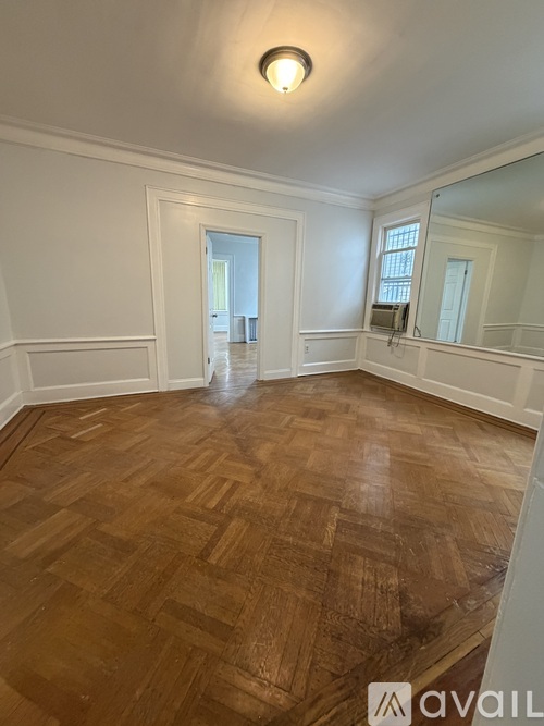 A room with wooden flooring and white walls.