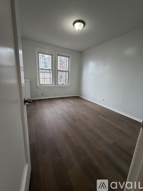 A room with wooden flooring and a window.