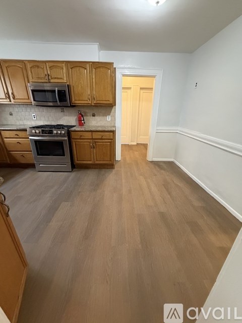 A kitchen with wooden cabinets and a stove top oven.