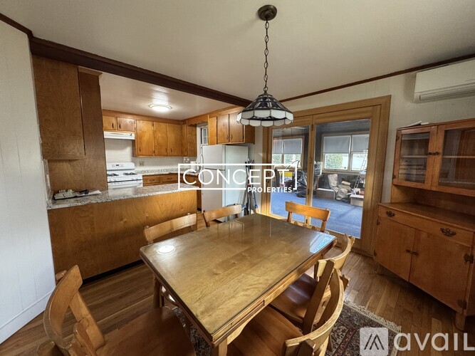 A dining room with a wooden table and chairs.