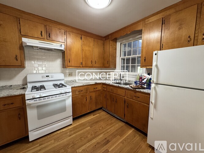 A bedroom with a bed, a chair, and two windows.