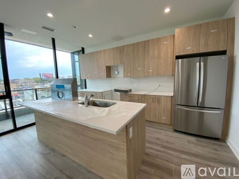 A modern kitchen with wooden cabinets and a stainless steel refrigerator.