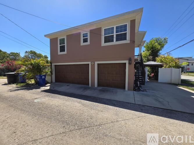 A two-story house with a brown garage door is for sale.