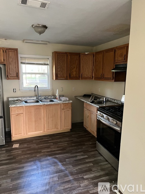 A kitchen with wooden cabinets and a stove top oven.