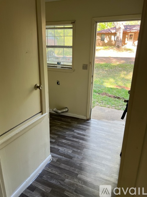 A hallway with a door leading to a backyard.