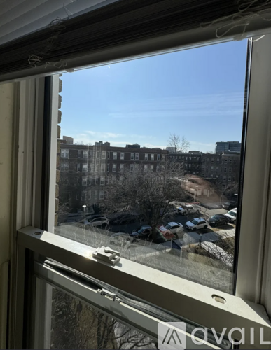 A view from a window looking out at a parking lot and buildings.