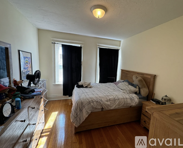 A bedroom with a bed, dresser, and window.