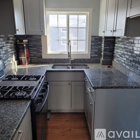 A kitchen with granite countertops and a stove top oven.