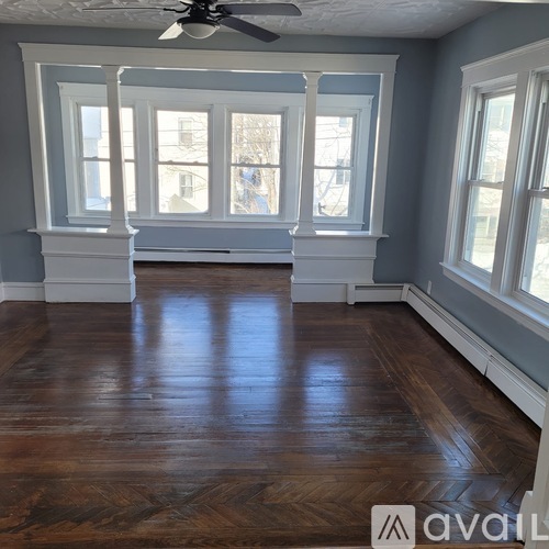 A room with wooden floors and white trimmed windows.