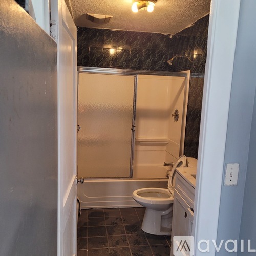 A bathroom with a toilet, sink, and shower.