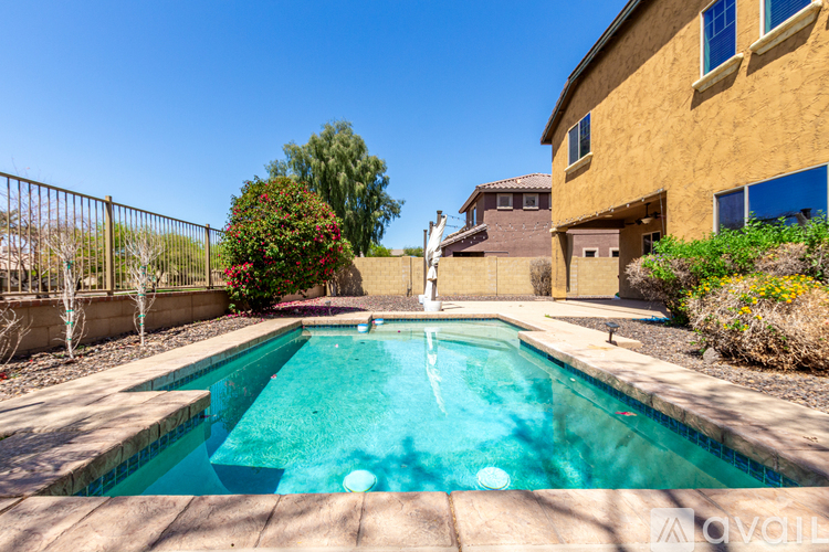 A small pool in a backyard with a house in the background.