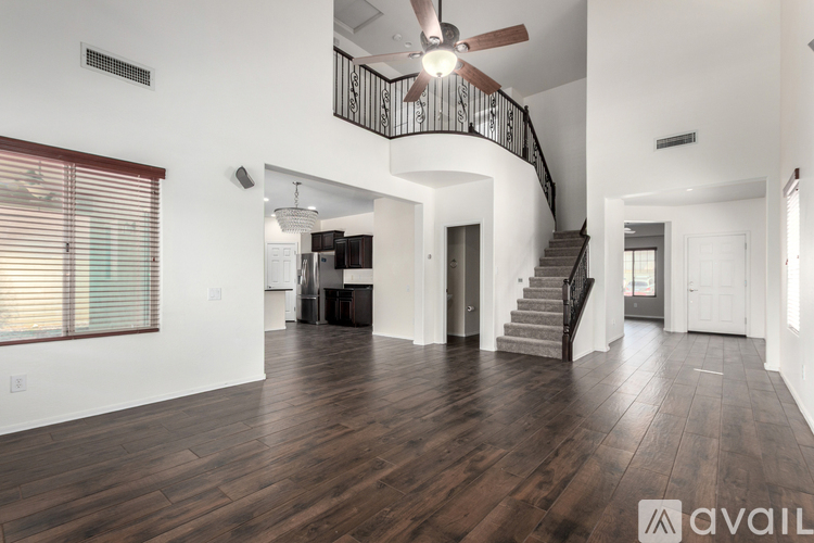 A spacious living room with a staircase leading to the upper level.
