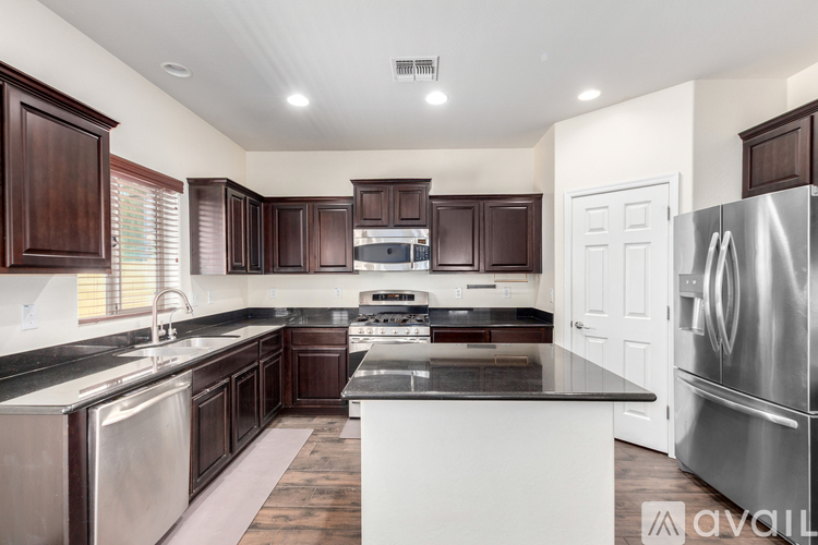 A kitchen with dark wood cabinets and stainless steel appliances.