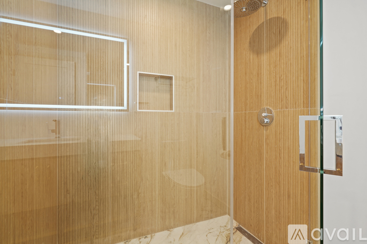 A bathroom with a glass shower door and a wooden door.