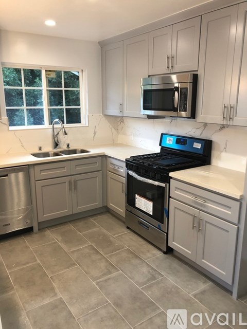 A kitchen with a black stove top oven and a window.