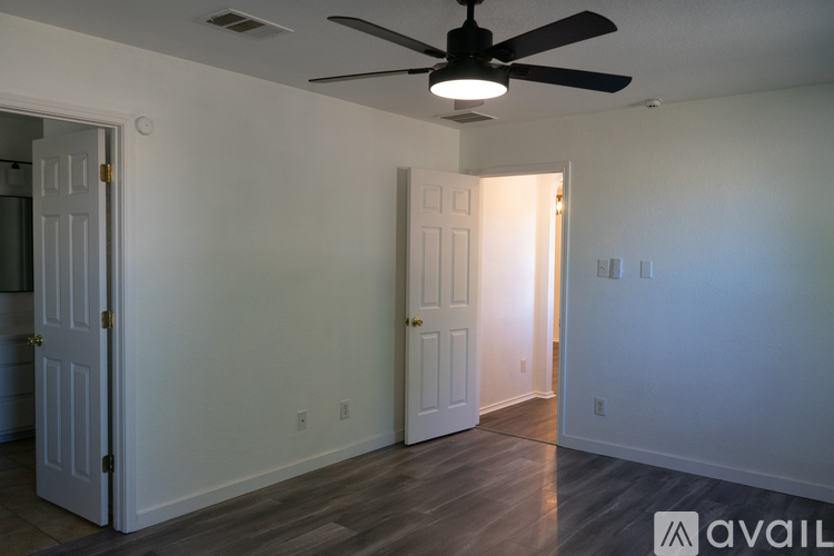 A room with a ceiling fan and two doors.