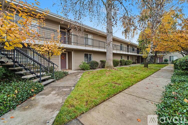 Apartment complex with a staircase and trees with fall foliage.