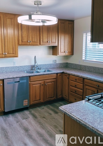 A kitchen with wooden cabinets and a granite countertop.