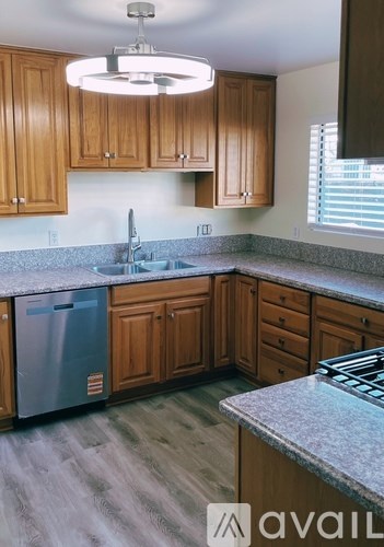 A kitchen with wooden cabinets and a granite countertop.