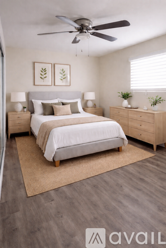 A bedroom with a bed, nightstands, and a ceiling fan.