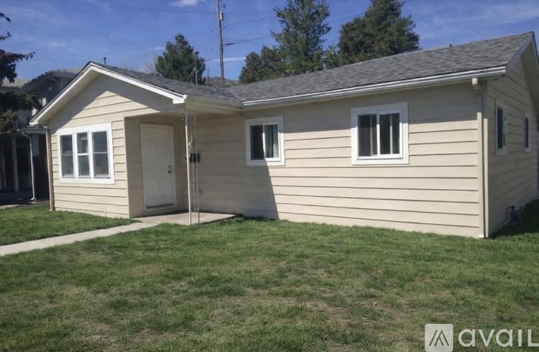 A house with a beige siding and a grey roof is available for purchase.