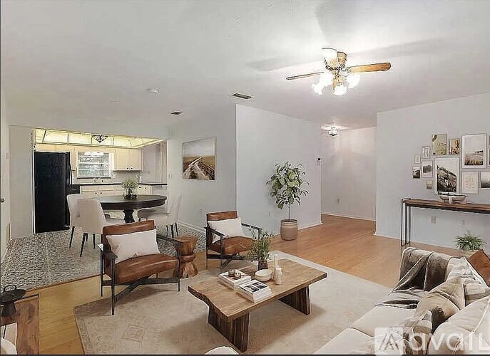 A living room with a couch, chairs, and a coffee table.