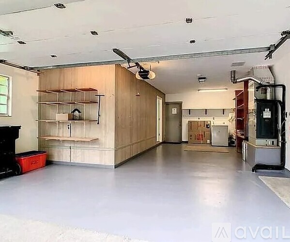 A spacious garage with a workbench and a red toolbox.