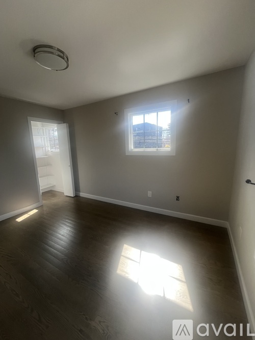 A room with a window and a door is available for rent.