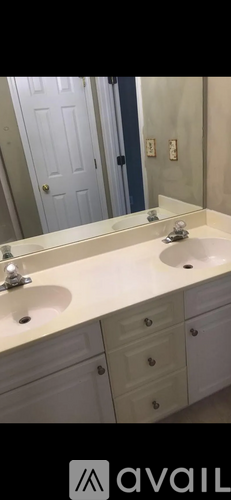 A bathroom with two sinks and a mirror.