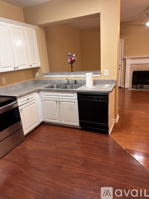 A kitchen with white cabinets and a black dishwasher.