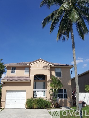 A house with a palm tree in front of it.