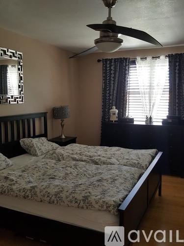 A bedroom with a large bed and a ceiling fan.